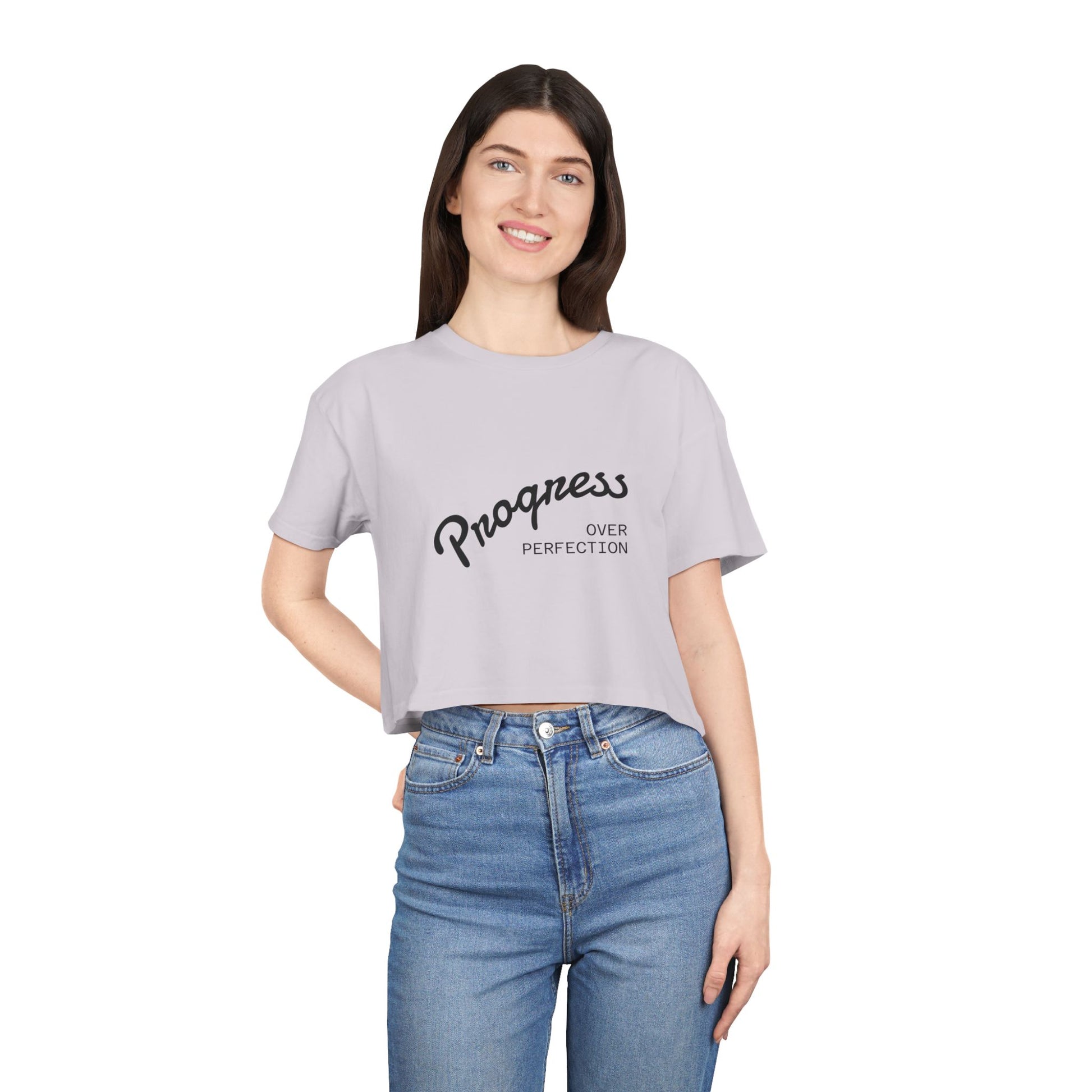 Woman wearing a gray t-shirt with 'Progress over Perfection' text on a white background