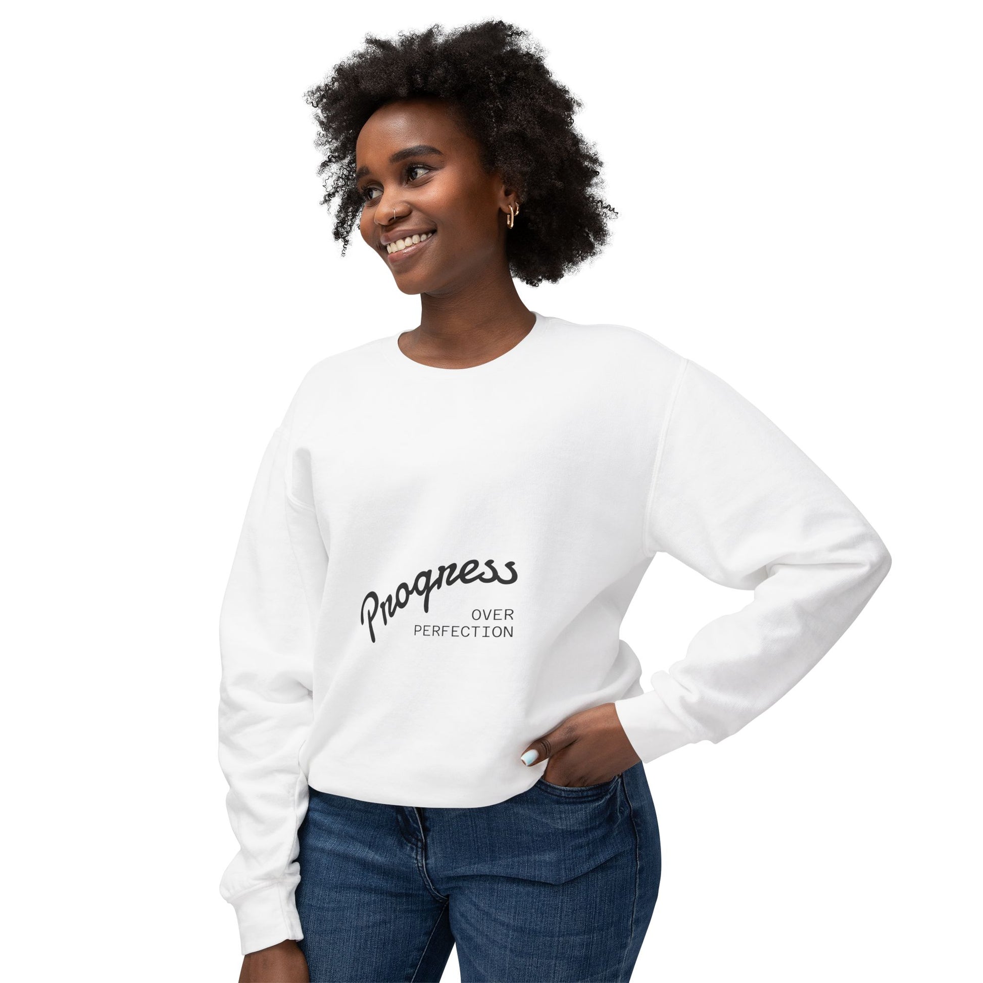 Woman wearing progress over perfection white crewneck sweatshirt with jeans, motivational casual apparel for everyday inspiration
