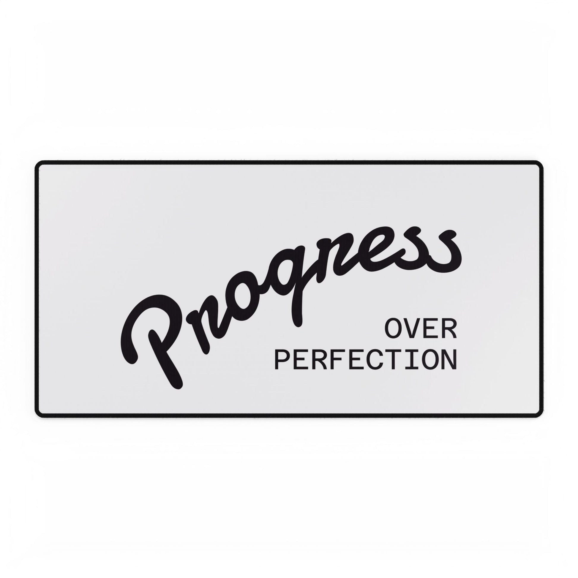 Progress Over Perfection white desk mat close-up showing black script typography
