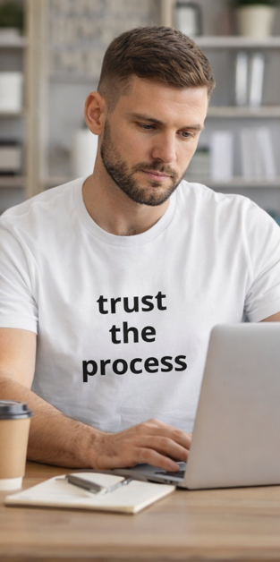 Man in Trust the Process white t-shirt working at desk motivational workwear
