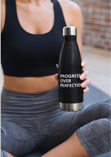 Woman holding Progress Over Perfection water bottle after workout fitness motivational drinkware