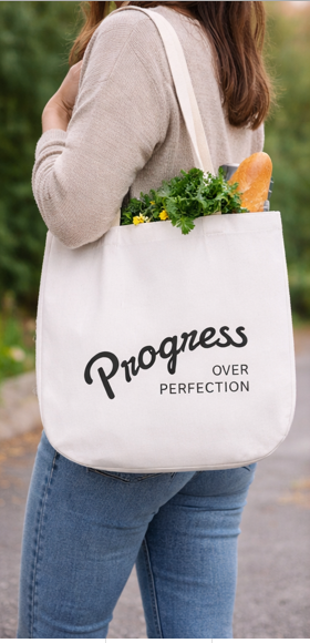Progress Over Perfection motivational quote tote bag held by woman in casual outfit