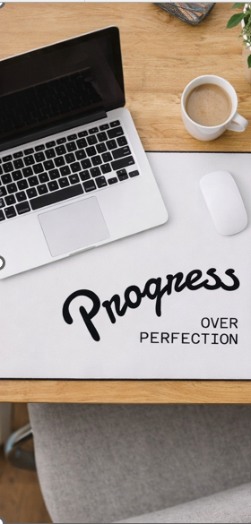 Progress Over Perfection motivational desk mat under laptop on wooden desk