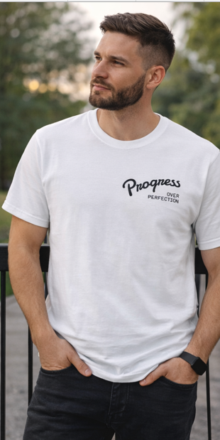 Man wearing Progress Over Perfection white unisex t-shirt casual outdoor setting