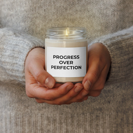 Hands holding Progress Over Perfection scented candle soy wax motivational self-care gift