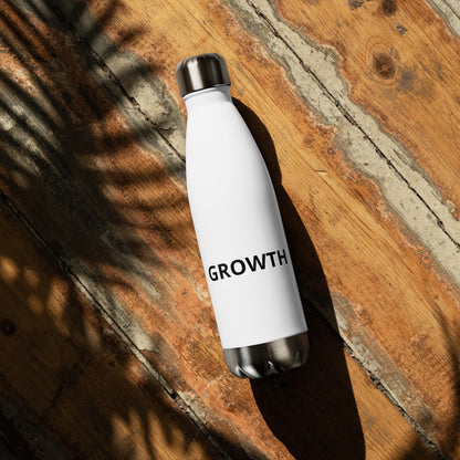 Growth motivational water bottle close-up on rustic wood, white insulated stainless steel bottle with motivational text

